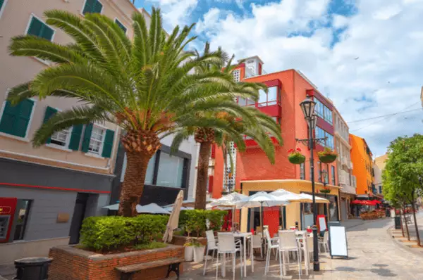 Main Street mit bunten Wohnhäusern in Gibraltar Main Street mit bunten Wohnhäusern in Gibraltar mit einem Straßencafé und einer großen Palme.