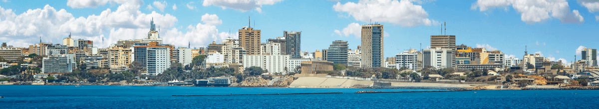 Blick auf die senegalesische Hauptstadt Dakar mit modernen Gebäuden und blauem Himmel mit ein paar Wolken, Afrika