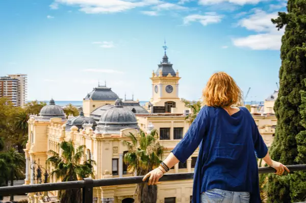 Frau mit blauem Hemd genießt die Aussicht auf die Stadt Málaga, Spanien
