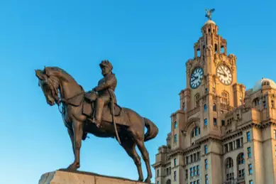 Von der Sonne erstrahlt steht das Denkmal vor dem Liverpooler Rathaus
