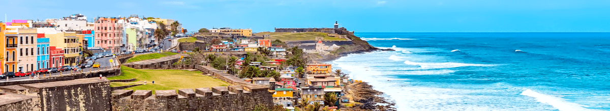Panorama von San Juana auf die Küstenstraße mit blauem Meer und vielen bunten Häusern, Puerto Rico