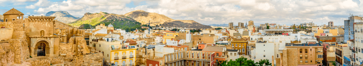 Panoramaaussicht auf Cartagena mit Bergen im Hintergrund und Häusern und einer alten römischen Ruine, Spanien
