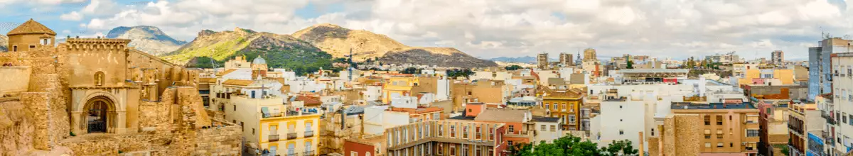 Panoramaaussicht auf Cartagena mit Bergen im Hintergrund und Häusern und einer alten römischen Ruine, Spanien