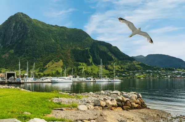 Rosendal - Küste und Blick auf den Hafen mit Segelbooten und Yachten mit den Bergen im Hintergrund, Norwegen