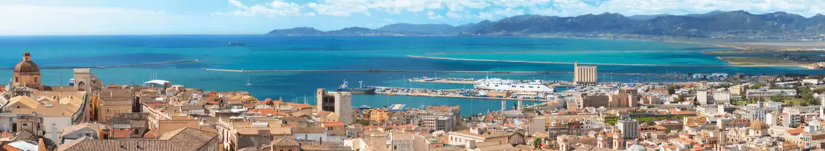 Blick von der Altstadt auf den Hafen von Cagliari, an dem gerade zwei Schiffe vor Anker liegen.