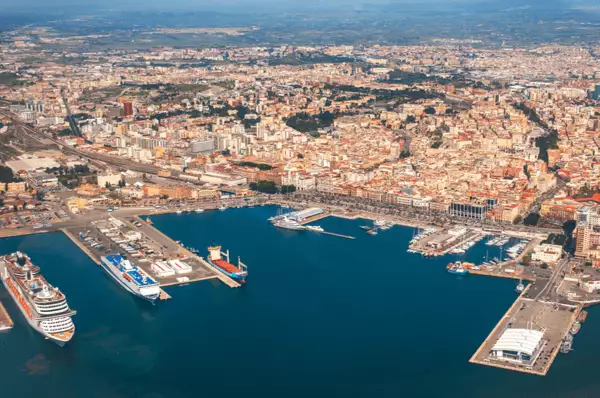 Blick auf den Hafen von Cagliari auf Sardinien Hafen von Cagliari mit einem Kreuzfahrtschiff, einem Containerschiff und verschiedenen kleineren Booten vor den Toren der Stadt.