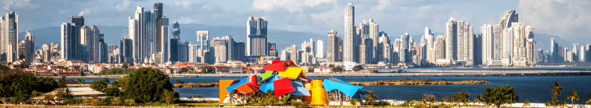 Skyline von Panama City mit dem kunterbunten Biomuseo im Vordergrund.