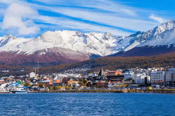 Luftbild Ushuaia mit weißen Bergen im Hintergrund und unzähligen kleinen Häusern der Stadt - Hauptstadt der argentinischen Provinz Tierra del Fuego