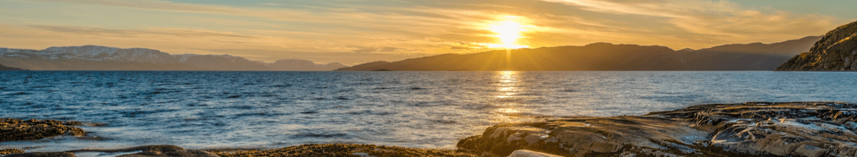 Mitternächtliche Sonne über dem Fjord bei Alta in der norwegischen Finnmark.