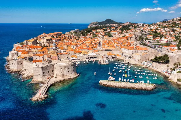 Kreuzfahrt Dubrovnik – Blick auf die historische Altstadt Luftaufnahme der historischen Altstadt von Dubrovnik mit der mittelalterlichen Stadtmauer und dem alten Hafen an der adriatischen Küste Kroatiens an einem sonnigen Tag.