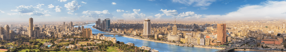 Panoramablick auf Kairo links und rechts des Nils mit einer Brücke, Hochhäusern und Grünanlagen.