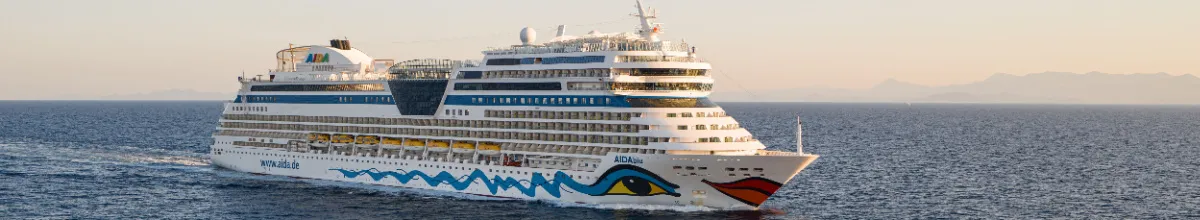 Lassen Sie die Seele baumeln dank der AIDA Winterpause und sichern Sie sich Ihr Bordguthaben Die AIDAblu seitlich auf dem Meer in klassischer Kussmundoptik.