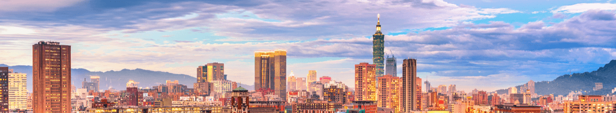 Skyline von Taipeh bei Sonnenuntergang mit zahlreichen Wolkenkratzern und Bergen im Hintergrund