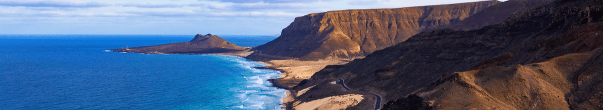 Luftbild des Strandes mit blauen Wasser, welches Wellen an der Küste von Mindelo auf der Insel Sao Vicente in Kap Verde schlägt