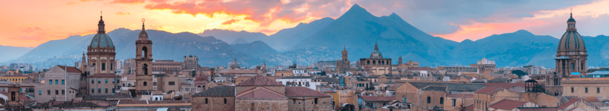 Die schöne Skyline von Palermo mit mehreren Kirchtürmen und Bergen im Hintergrund.