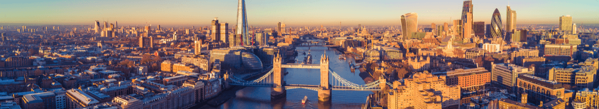 Eine Luftaufnahme von Londons Skyline mitsamt der Themse, Tower Bridge, dem Big Ben und The Shard, sowie den zahlreichen Häusern der Metropole.