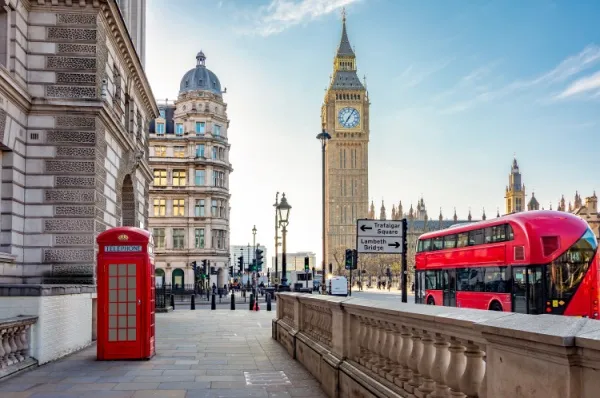 Kreuzfahrt nach London Von dem berühmten Big Ben fährt ein roter Doppeldeckerbus an einer roten englischen Telefonkabine vorbei.