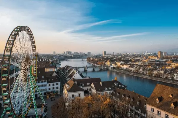 Die Skyline von Basel mit einem Riesenrad während der Herbstmesse