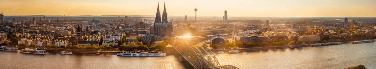 Panoramablick auf das Kölner Rheinufer im Sonnenaufgang