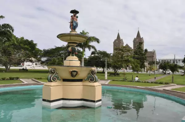 Der Springbrunnen am Independence Square in Basseterre zeigt drei afrikanische Frauen und ein Kind, die sich um eine Säule herum gruppieren. Darunter befindet sich das runde Bassin.