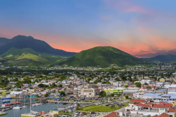 Hinter den Bergen von St. Kitts versinkt die Sonne und taucht die Hauptstadt Basseterre in ein romantisches Licht.