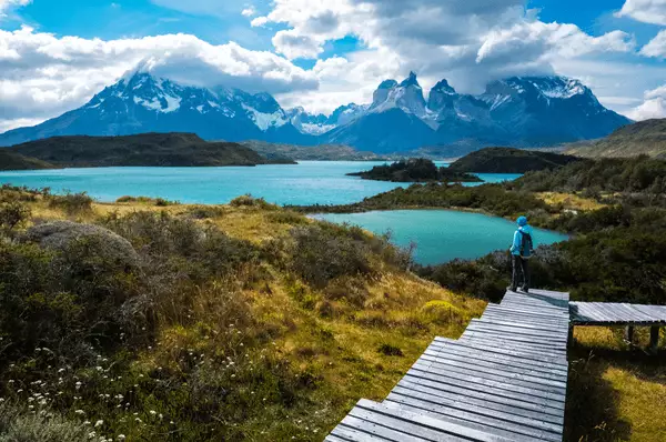 Wanderer mit blauer Regenjacke und Rucksack im Torres del Paine Nationalpark, Chile
