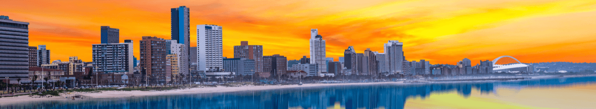 Durban Strand Skyline, die sich im Wasser widerspiegelt im Sommer bei Dämmerung, Südafrika