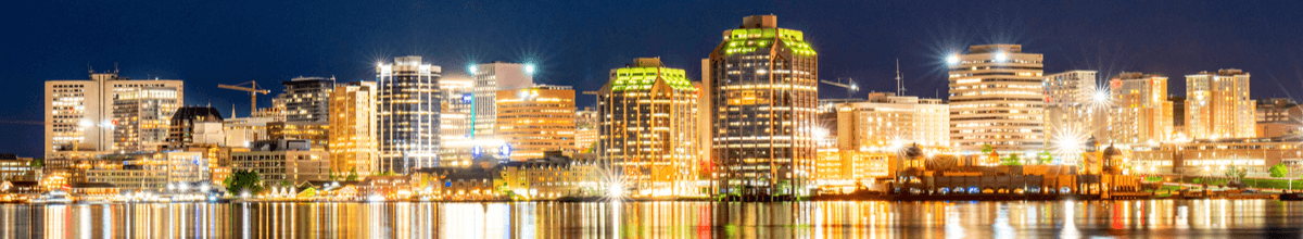 Skyline von Halifax, Nova Scotia, bei Nacht entlang der Uferpromenade mit hell erleuchteten Gebäuden, die sich im Wasser widerspiegeln