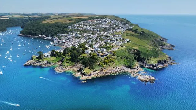 Küstenstadt am Meer mit Felsen und blauem Himmel.