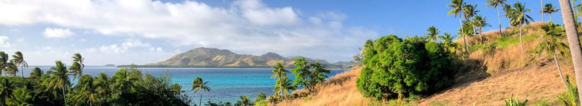 Fidschi - Blick von den Yasawa Inseln mit Palmen, Meer und einer Insel im Hintergrund