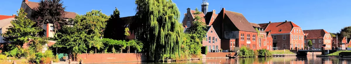 Rote Häuser und Bäume am Kanal- Ufer