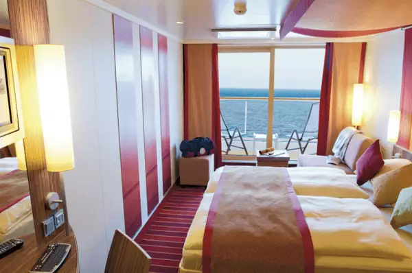 Balkonkabine auf AIDAbella Kabine mit Balkon, Doppelbett, Sessel sowie Tisch und Stühlen im Außenbereich