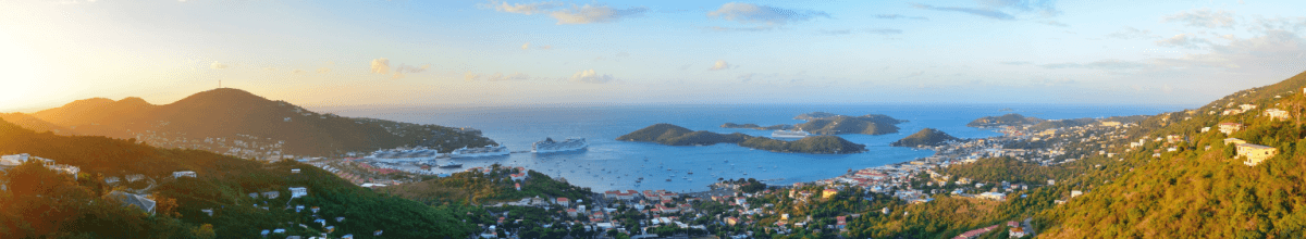 St. Thomas Sonnenaufgang Panorama mit bunten Wolken, Gebäuden und Strandküste.