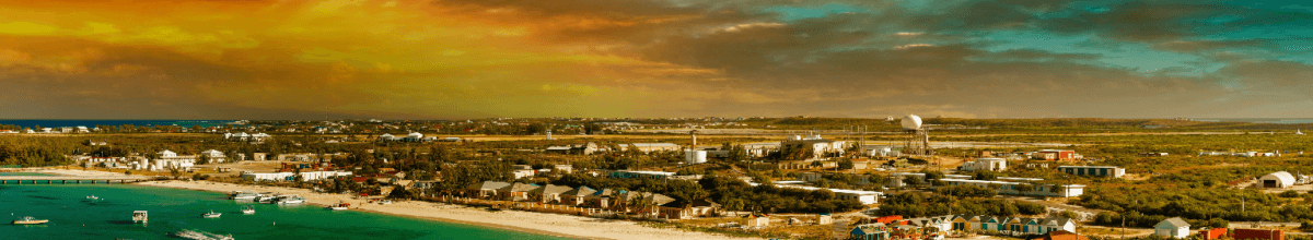 Im zauberhaften Licht sehen sie Grand Turk Island in Panorama Ansicht. links im Bild sieht man das Meer und rechts im Bilddie Stadt selber.