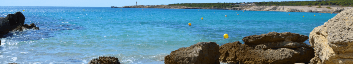 Eine kleine Bucht die zum Schwimmen einläd ist zu sehen. Ebenfalls schwimmen Boyen im Meer.