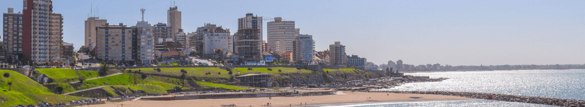 Ein Panoramerausschnitt von Mar del Plata. Neben Hochhäusern sieht man das Meer und den Strand.
