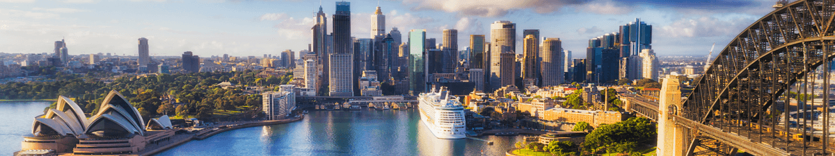 Sydney mit dem berühmten Opernhaus und einem Kreuzfahrtschiff im Hafen.