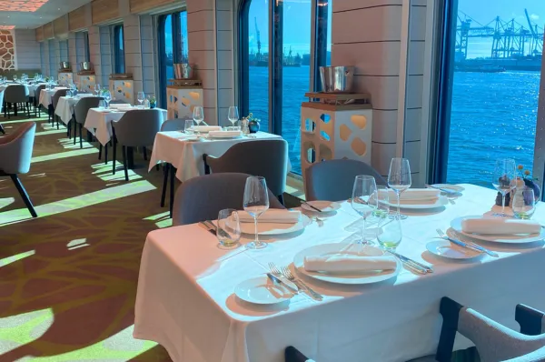 Das Hauptrestaurant der HANSEATIC spirit Das Hauptrestaurant ist mit gedeckten Tischen ausgestattet. Die Stühle und Bänke sind beige gehalten.