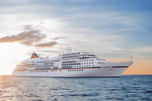 Auf dem Meer fährt die MS Europa in den Sonnenuntergang.