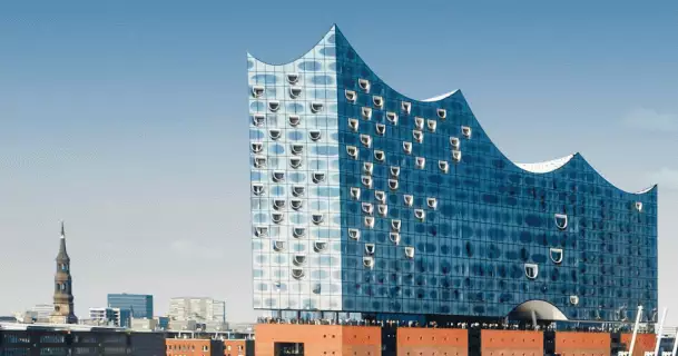 Vor der Elbphilharmonie fährt die MS Europa auf dem Gewässer.