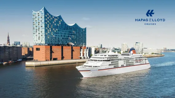 Vor der Elbphilharmonie fährt die MS Europa auf dem Gewässer.