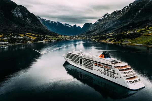 Unvergessliche Kreuzfahrt durch die norwegischen Fjorde mit Hapag-Lloyd Cruises Hapag-Lloyd Cruises Luxusschiff (MS Europa 2) im Geirangerfjord, Norwegen – Atemberaubende Fjordlandschaft mit Bergen und Wasserfällen.