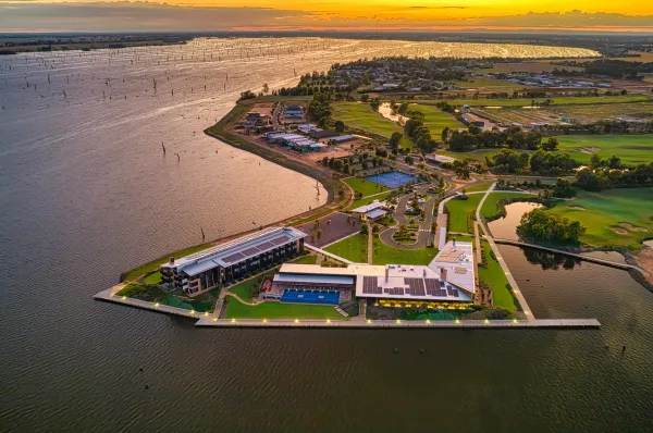 Golf & Cruise Traumziele: Weltklasse-Golfanlagen in spektakulärer Küstenlage Luftaufnahme eines exklusiven Golfresorts direkt am Wasser bei Sonnenuntergang als Ziel einer Golf & Cruise Reise mit Hapag-Lloyd Cruises.