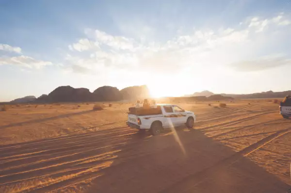 Wüstenausflug In der Wüste fährt ein weißer Jeep bei einem Landausflug von Hapag-Lloyd.