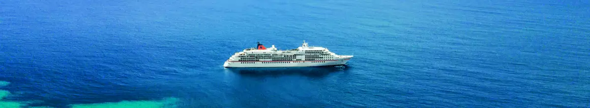 Ein Kreuzfahrtschiff fährt übers ruhige Meer.