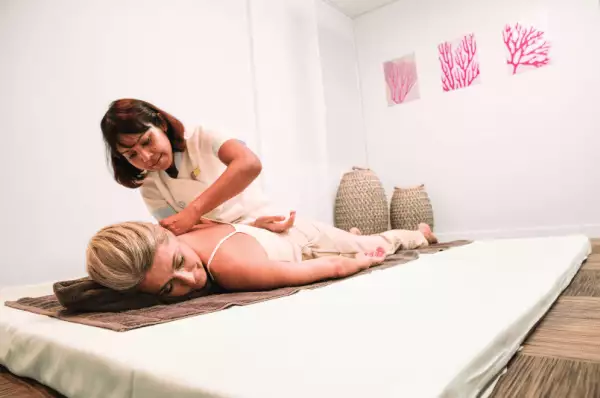 Spa und Wellness an Bord Eine Frau liegt auf einer Massageliege und wird von einer Masseurin massiert.