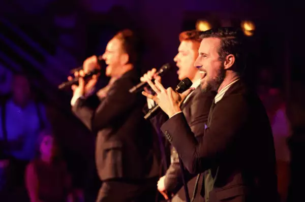 Gesangsauftritt Drei Männer stehen mit Mikrofon auf der Bühne und performen eine Show für die Gäste des Kreuzfahrtschiffs.
