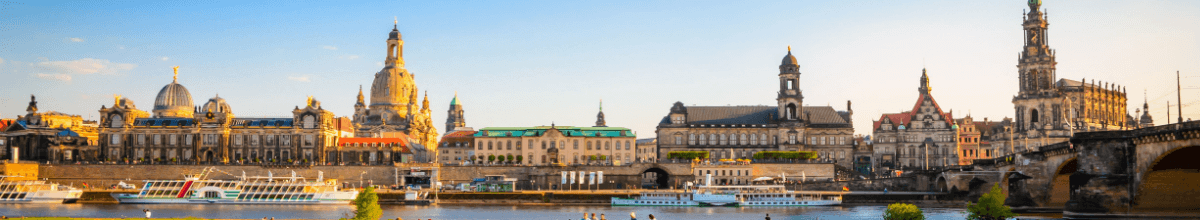 Gebäude der Altstadt von Dresden mit der Elbe im Vordergrund.