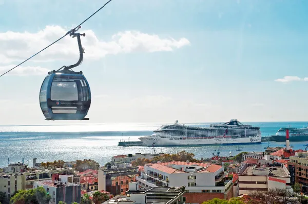 Ein Landgang auf Madeira bietet beeindruckende Ausblicke auf die majestätische MSC Divina Blick aus einer Seilbahn in Funchal auf die im Hafen von Madeira liegende MSC Divina während einer Kreuzfahrt.