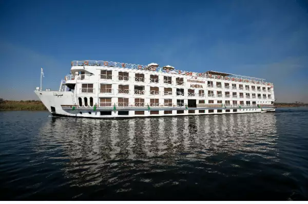 Zu sehen ist das große und auch hohe Schiff STEIGENBERGER LEGACY, wie es den Nil bereist. Es handelt sich um ein Schiff der Flotte von nicko cruises.